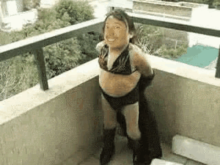 a little girl is standing on a balcony wearing a bikini .