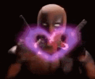deadpool is making a heart shape with his hands in a dark room .