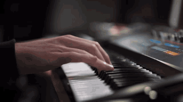 a close up of a person playing a piano with a blurred background