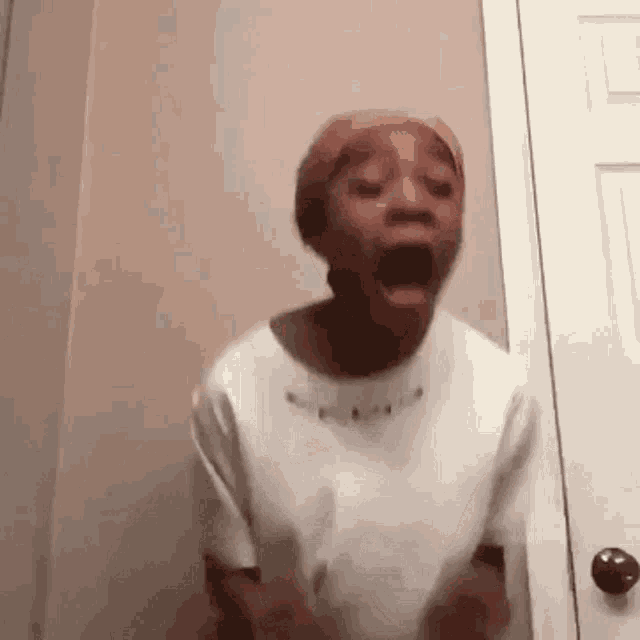 a woman is standing in a room with her mouth open .