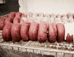 a bunch of red donuts with white frosting on them
