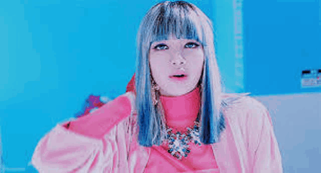 a woman with blue hair and a pink jacket is wearing a pink sweater and a necklace .
