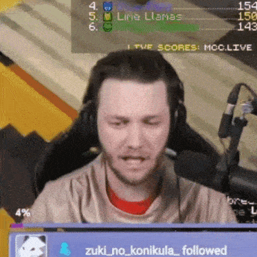 a man wearing headphones is sitting in front of a microphone and a scoreboard that says lima llamas