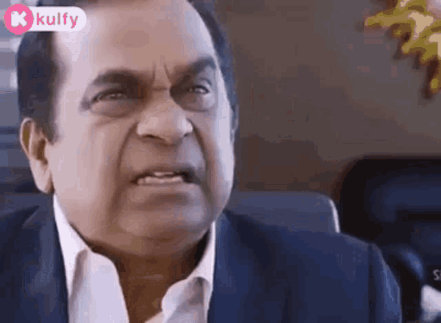 an older man in a suit and white shirt is making a funny face .