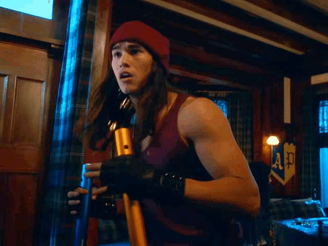 a woman in a red beanie is holding a pole in a room