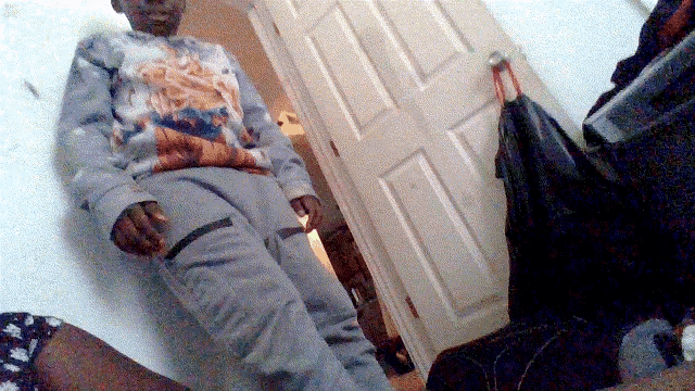 a man in a tie dye shirt is standing next to a door