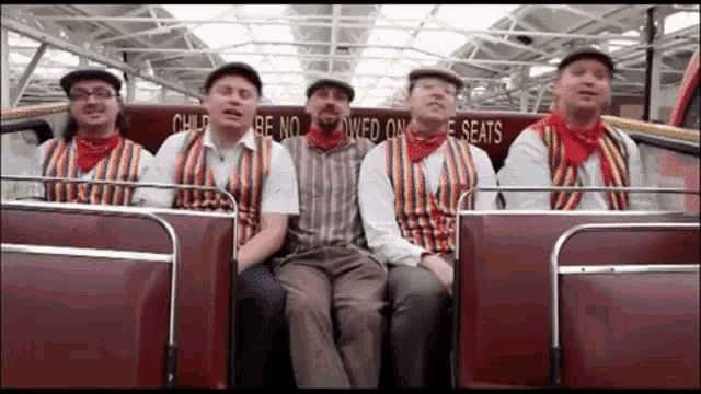 a group of men are singing on a bus with a sign that says child be no wed on the seats