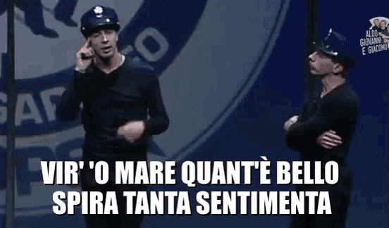 two men are standing in front of a sign that says vir ' o mare quant 'e bello spira tanta sentimenta