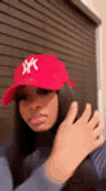 a woman wearing a red hat and a turtleneck is taking a selfie .