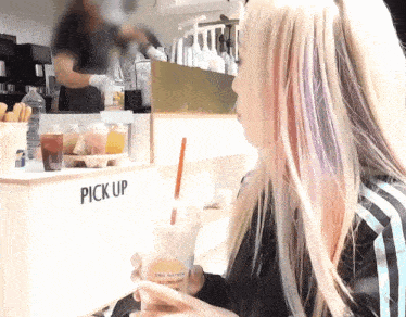 a woman sitting in front of a pick up counter