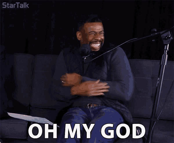 a man is sitting on a couch in front of a microphone and says oh my god .