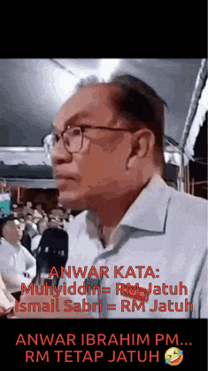 a man wearing glasses and a white shirt is standing in front of a crowd of people .