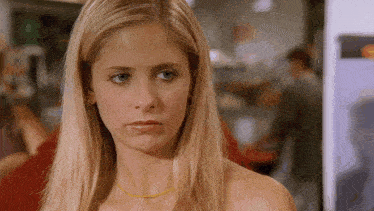 a close up of a woman 's face with a yellow necklace around her neck