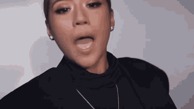 a close up of a woman wearing a black jacket and a turtleneck .