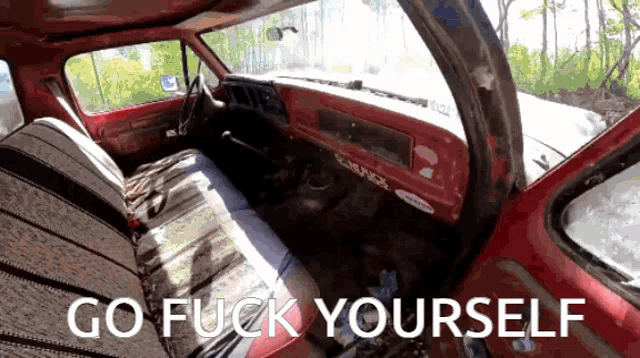 the inside of a red truck with the words go fuck yourself on the bottom