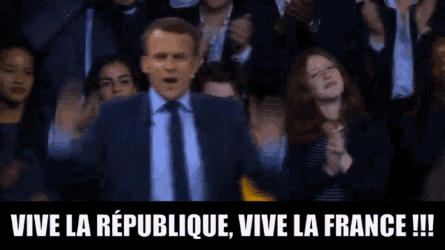 a man in a suit and tie stands at a podium with the words vive la republique vive la france written on the bottom
