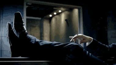 a man in a suit is smoking a cigar