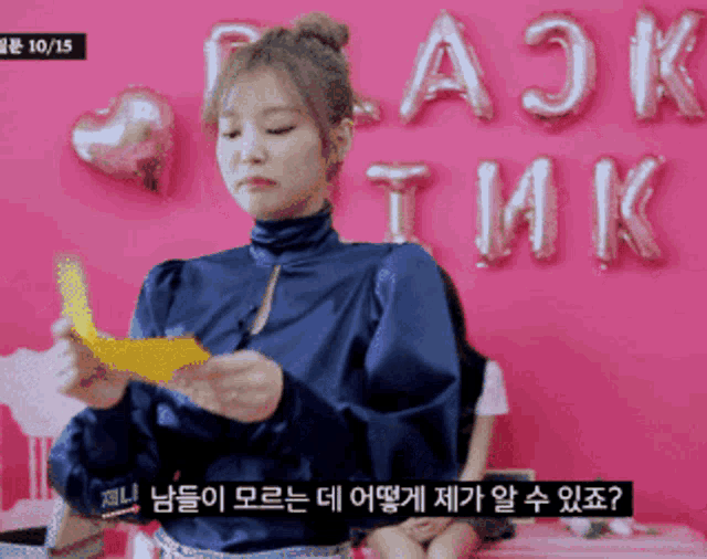 a girl in a blue shirt is standing in front of balloons that say blackpink