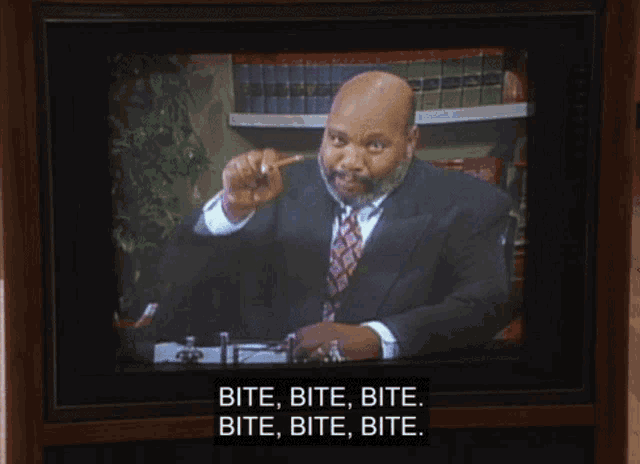 a tv screen shows a man in a suit and tie and says bite bite bite bite