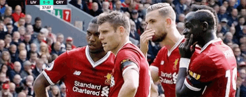 a group of soccer players wearing red uniforms with the word standard chartered on them