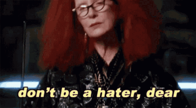 a woman with red hair and glasses is saying " don 't be a hater , dear "