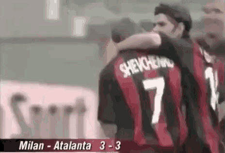 a group of soccer players are hugging each other . one of the players is wearing a number 7 jersey .
