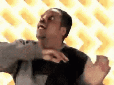 a man is making a funny face while dancing in front of a yellow background .