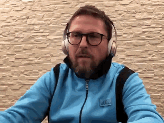 a man wearing headphones and a blue jacket with the word gucci on the front