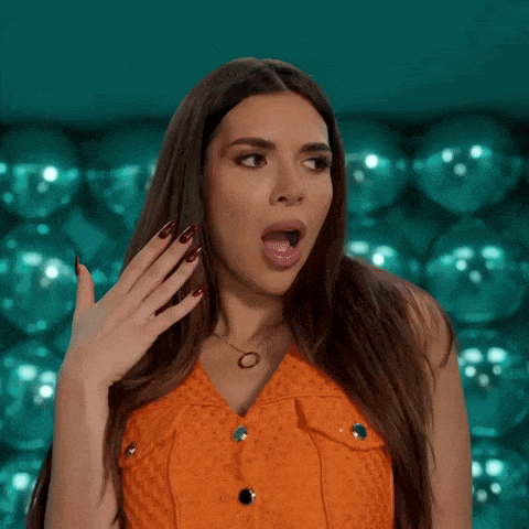 a woman with a surprised look on her face is wearing an orange dress