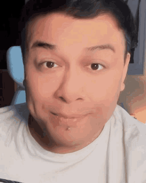 a close up of a man 's face with a white shirt