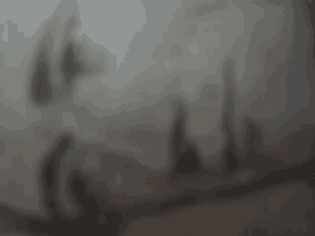 a blurry picture of a person 's face with a shadow on the wall .