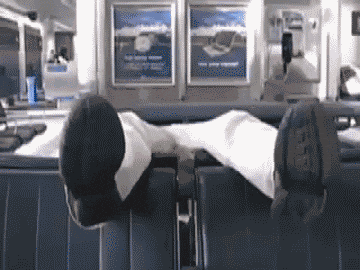 a person laying on a couch with their feet up and a sign behind them that says ' a ' on it