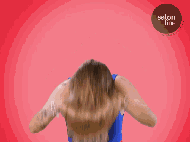 a woman in a blue tank top with a salon line logo in the background