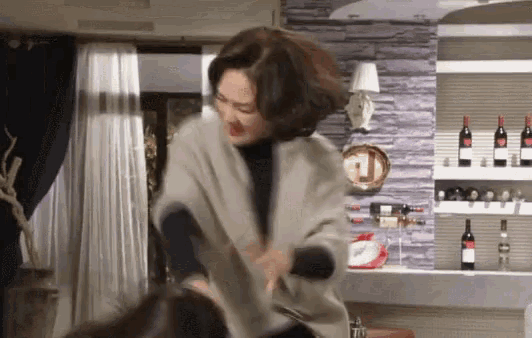 a woman is fighting another woman in a living room