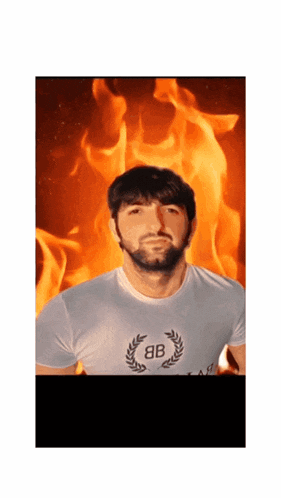 a man with a beard wearing a white shirt with the letter b on it