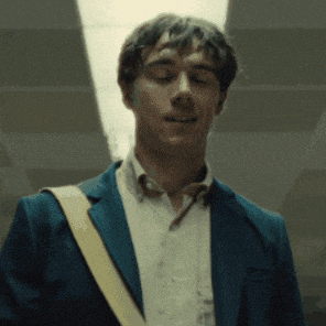 a man wearing a blue jacket and a white shirt is smiling