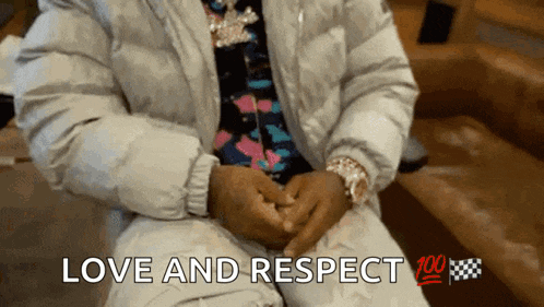 a man in a white jacket is sitting on a couch with the words love and respect written below him