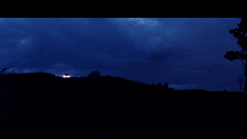 a truck is driving down a road at night