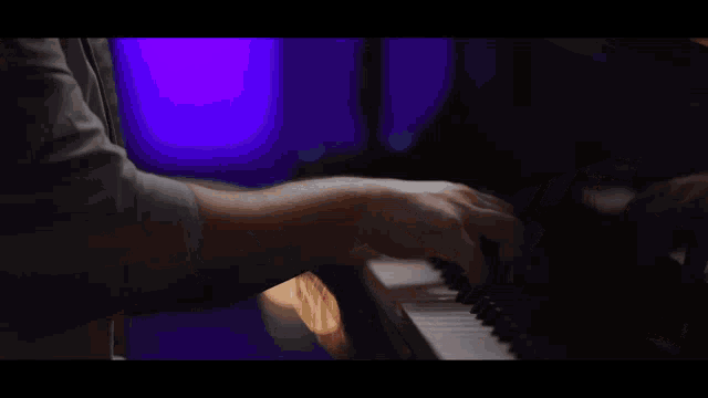 a man playing a piano and singing into a microphone