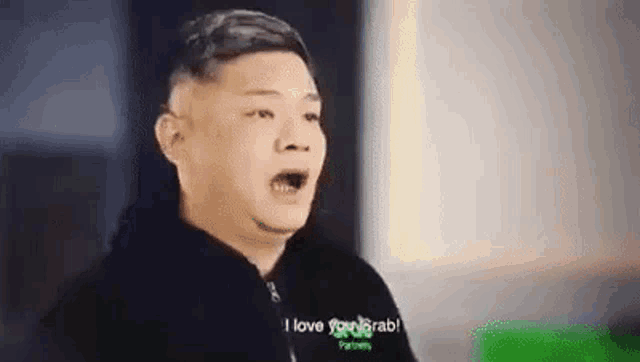 a man is making a funny face and saying `` i love you grab '' while wearing a black jacket .