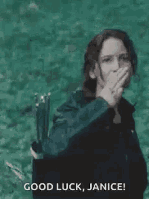 a woman is holding a bow and arrow and covering her mouth with her hand while standing in the water .