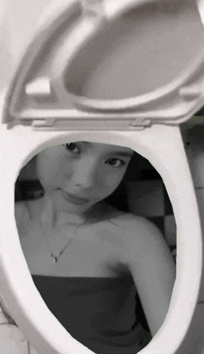 a black and white photo of a woman taking a selfie in a toilet seat