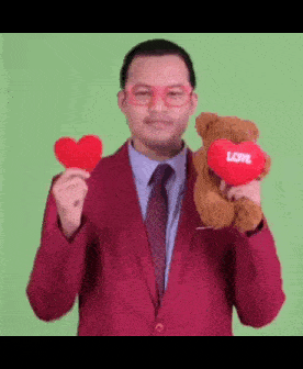 a man in a red suit is holding a teddy bear and a heart with the word love on it
