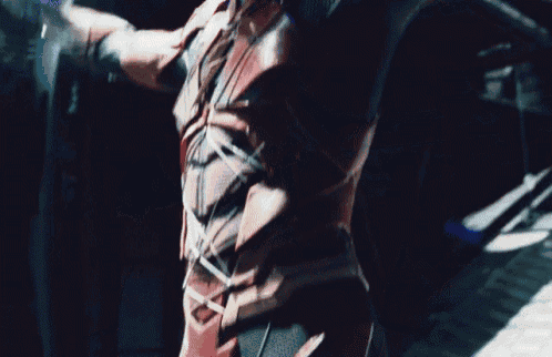 a man in a superhero costume is holding a bow and arrow .