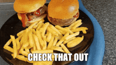 two hamburgers and french fries on a black plate with check that out written on it