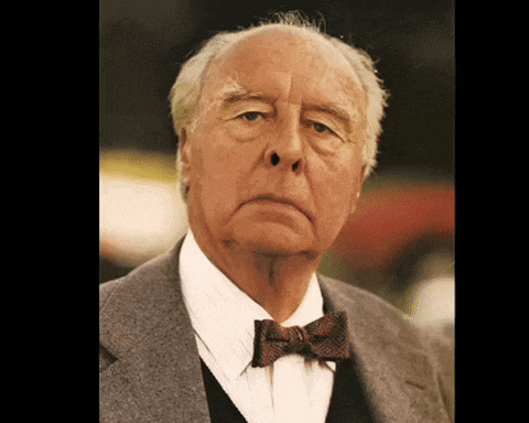 an older man wearing a bow tie and a suit