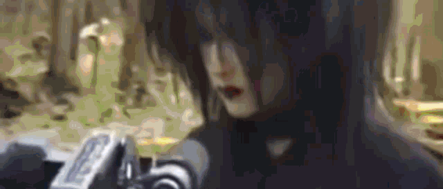 a woman with long black hair is holding a camera in her hands .