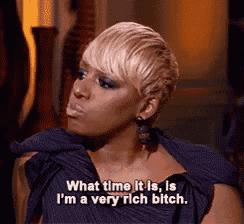 a woman in a purple dress is saying what time it is , i 'm a very rich bitch .