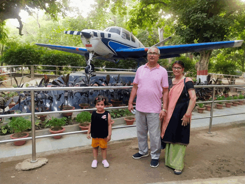a man and woman standing in front of a small plane