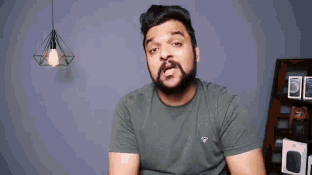 a man with a beard is making a funny face while wearing a t-shirt .